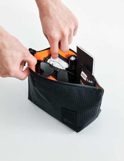 Dopp Kit The Brown Buffalo, black exterior orange interior, holds sunglasses and earbuds on Tampa Home & Garden Store