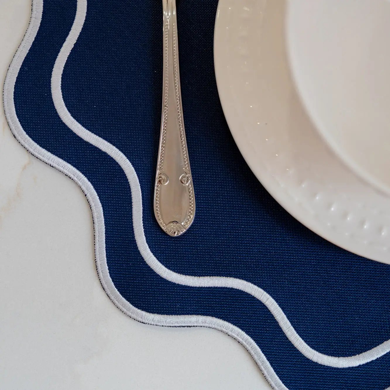 Solid Navy Wave Placemat by Talah Home, navy fabric with white piping wave edge on Tampa Home & Garden Store