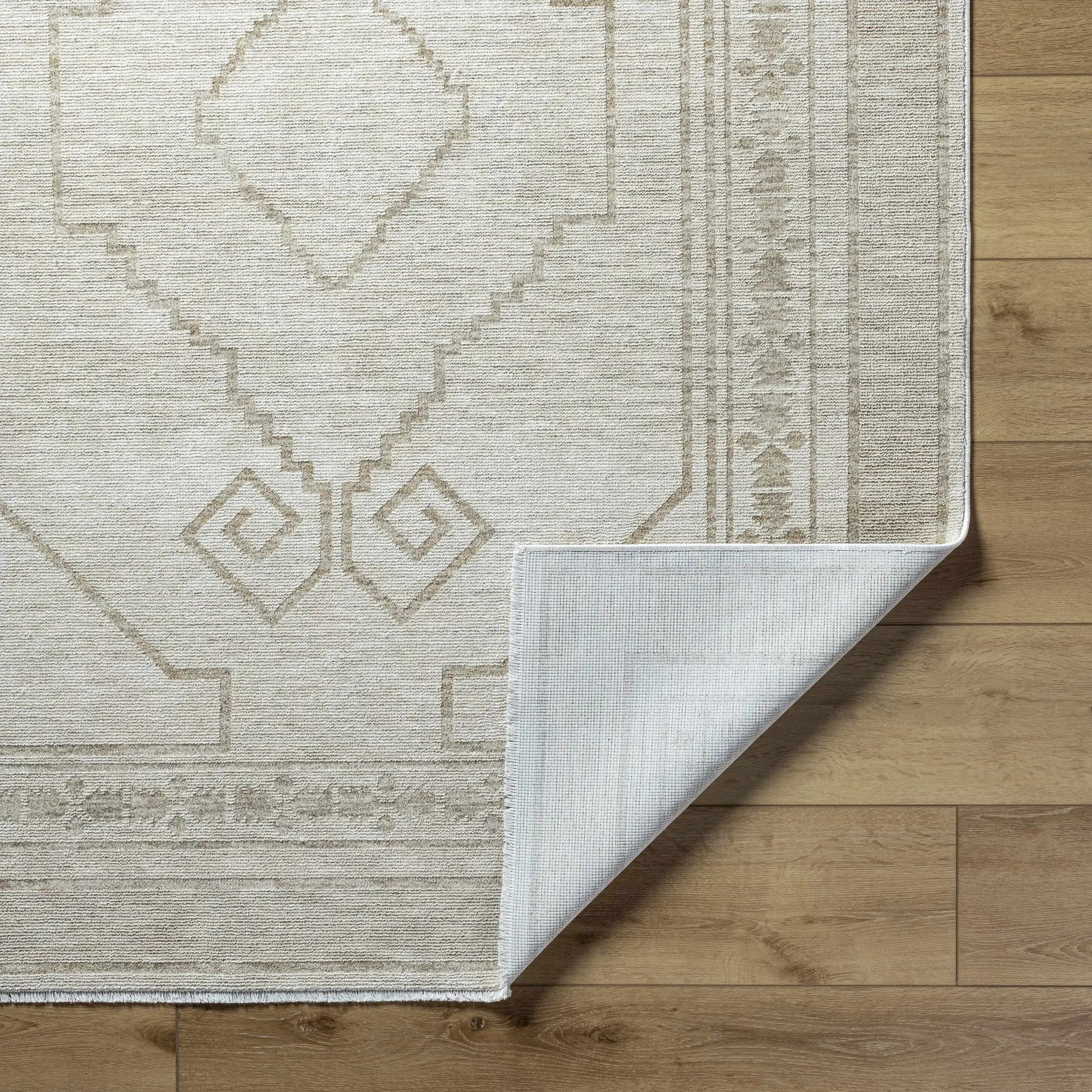 Taban Luxe Rug neutral beige with geometric diamond border on wood floor on Tampa Home & Garden Store