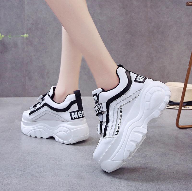 Pair of white chunky sneakers with black trim and side stripe casual fashion footwear on Tampa Home & Garden Store