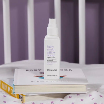 This Works Baby Sleep Pillow Spray bottle, white with lavender label, 75ml, atop baby books on Tampa Home & Garden Store
