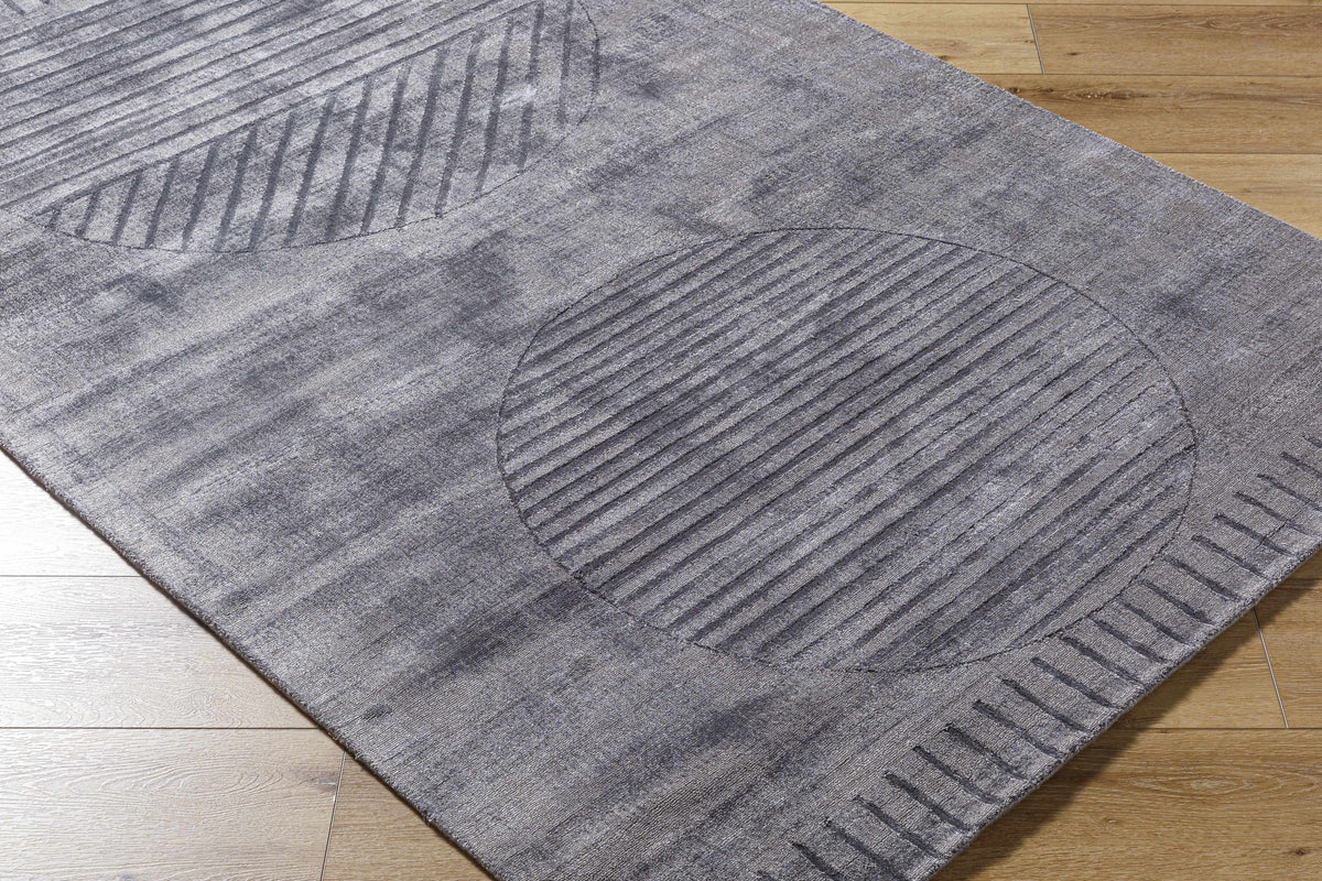 Timna Area Rug gray textured rug with arc and stripe patterns on wood floor on Tampa Home & Garden Store