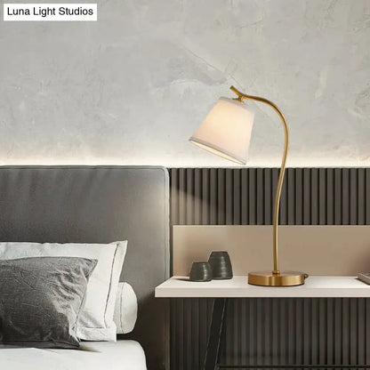 Brass bucket table lamp with gold arc and white lampshade by Decorbites on bedroom bedside table on Tampa Home & Garden Store