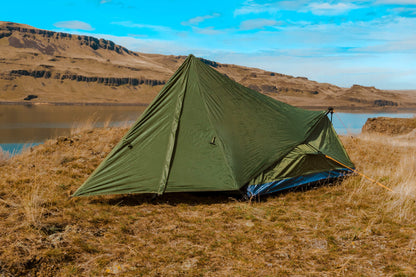 Trekker Tent 1V by River Country Gear, olive-green 1-person backpacking tent beside a lake on Tampa Home & Garden Store