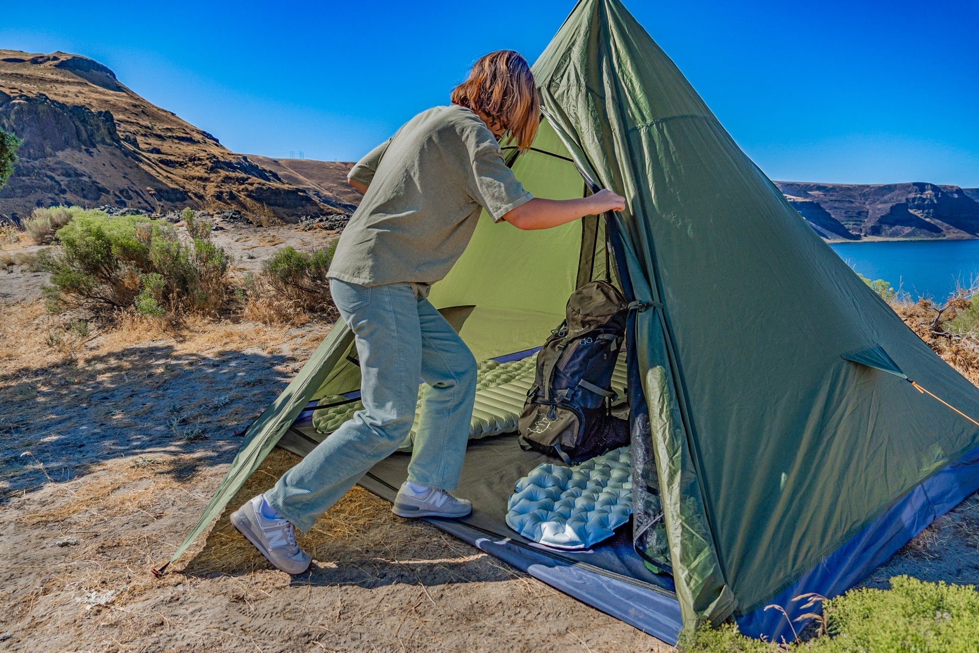 Trekker Tent 4 by River Country Gear green pyramid tent with a hiker entering on Tampa Home & Garden Store