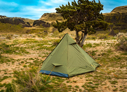 Trekker Tent 1 by River Country Gear, green 1-person backpacking tent pitched beside a tree in a desert landscape on Tampa Home & Garden Store