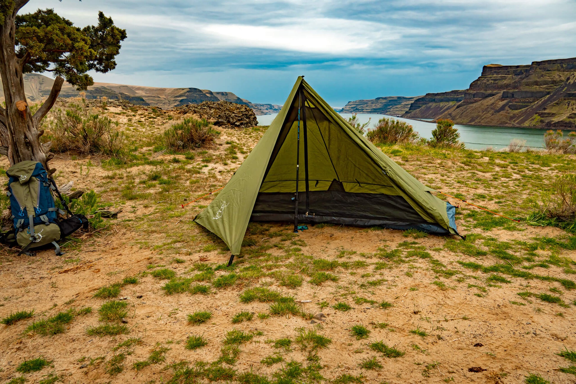 Trekker Tent 1 olive green 1-person backpacking tent pitched on sandy desert shore beside river on Tampa Home & Garden Store