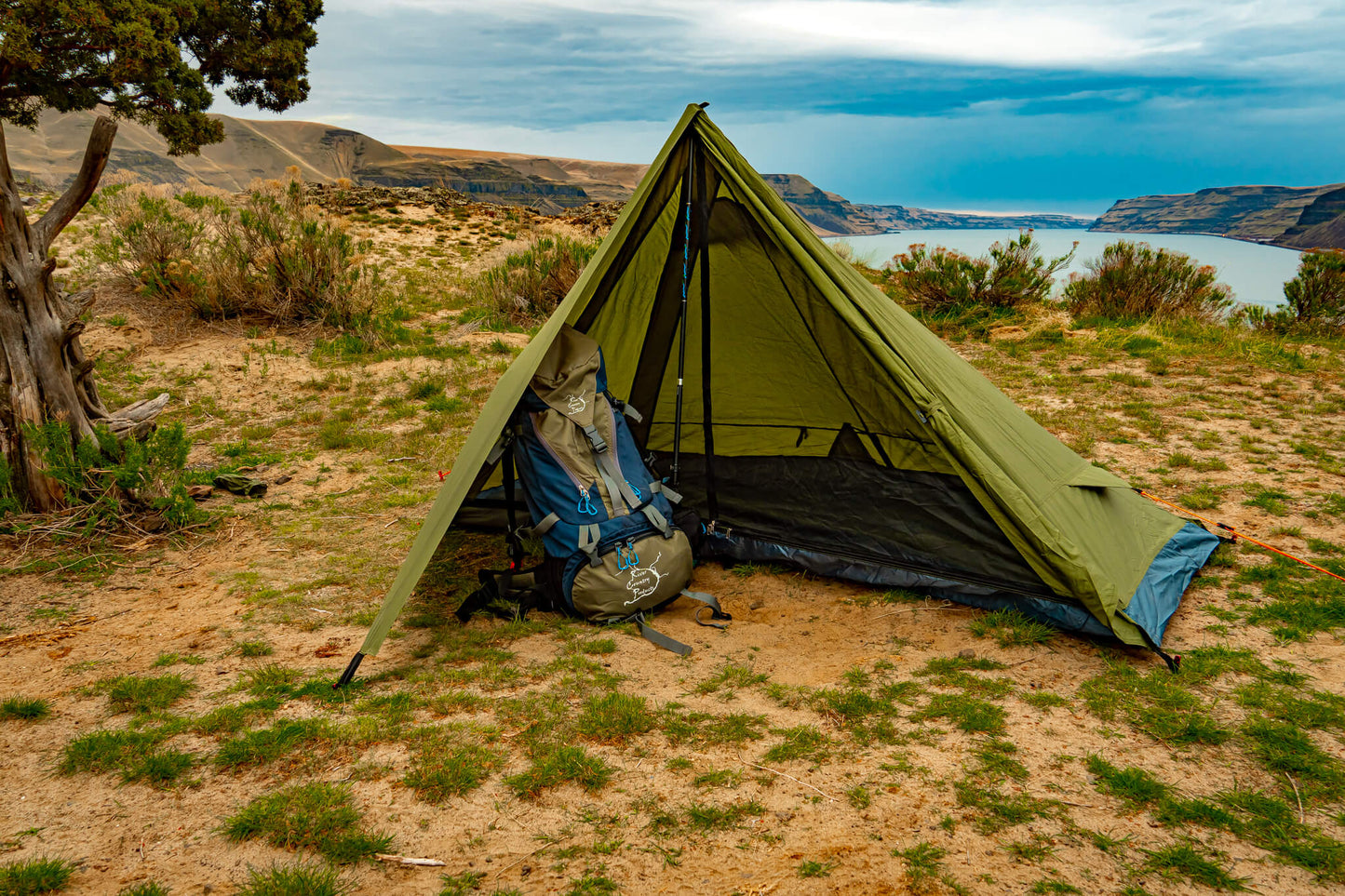 Trekker Tent 1 1-person backpacking tent olive-green with gear by campsite overlooking lake on Tampa Home & Garden Store