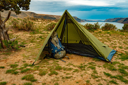 Trekker Tent 1 1-person backpacking tent olive-green with gear by campsite overlooking lake on Tampa Home & Garden Store