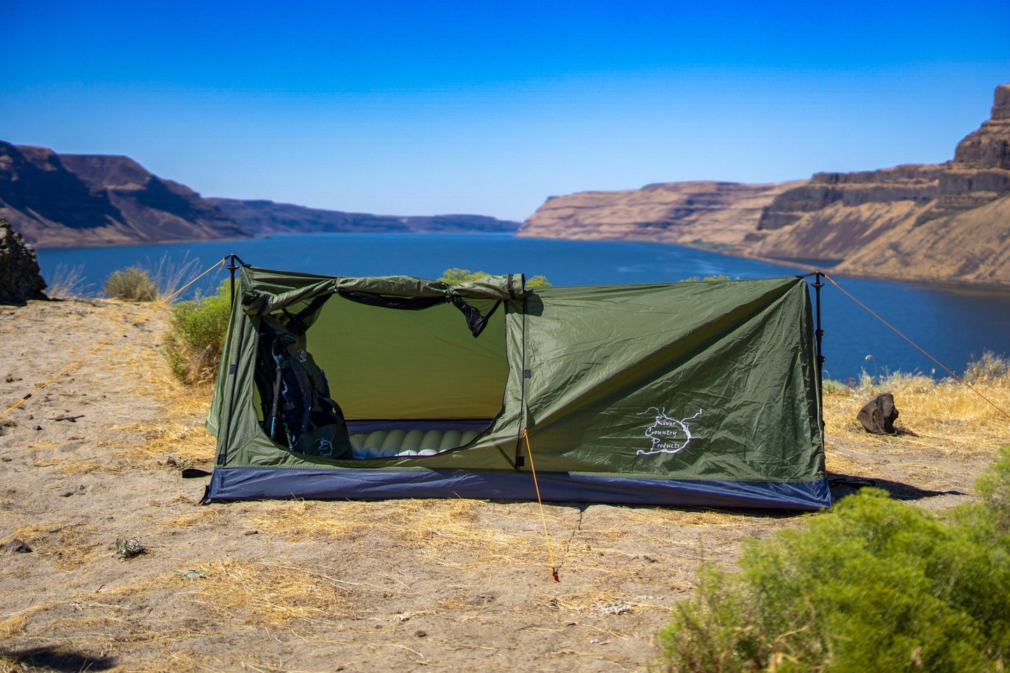 Trekker Tent 1A by River Country Gear, olive green 1-person backpacking tent by a blue lake on Tampa Home & Garden Store