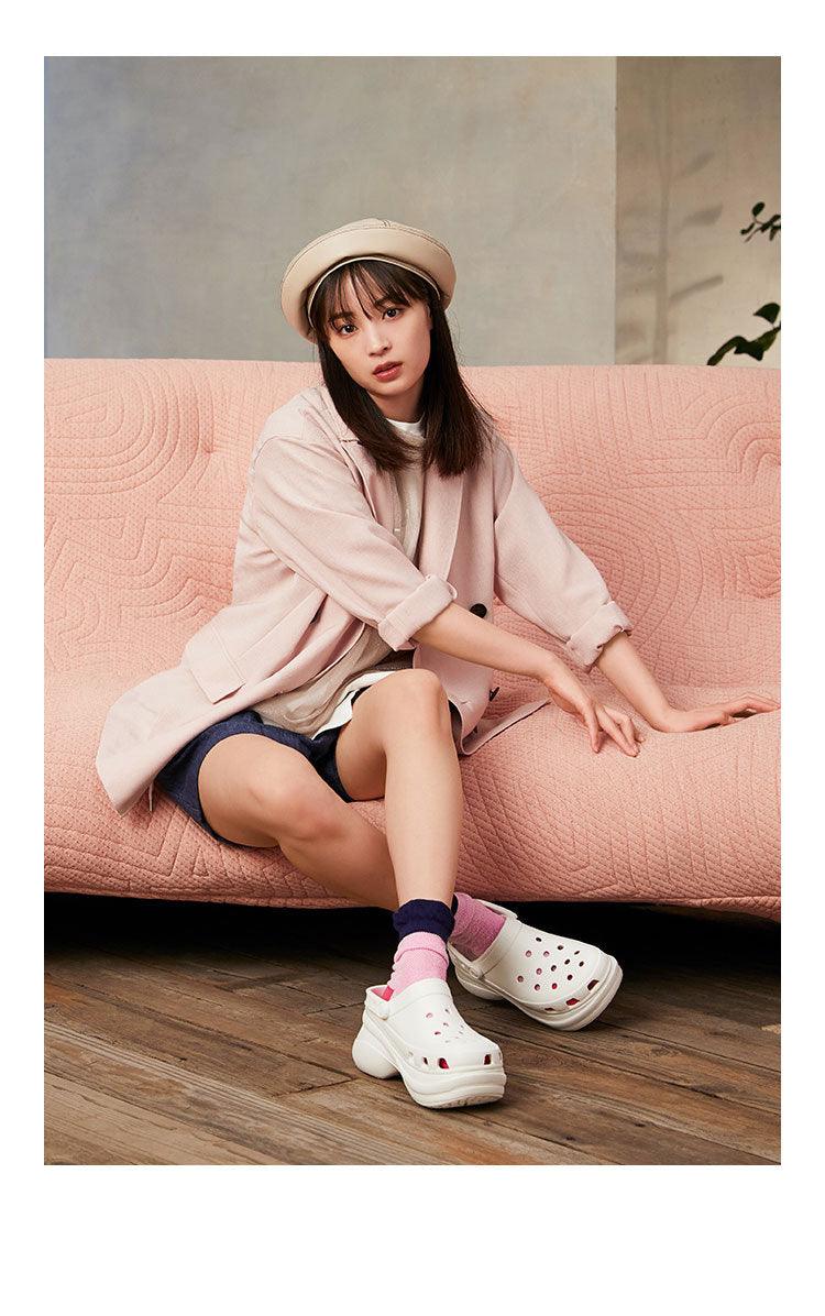 White platform garden sandals with perforated holes, slip-on clogs on model in pink coat on Tampa Home & Garden Store