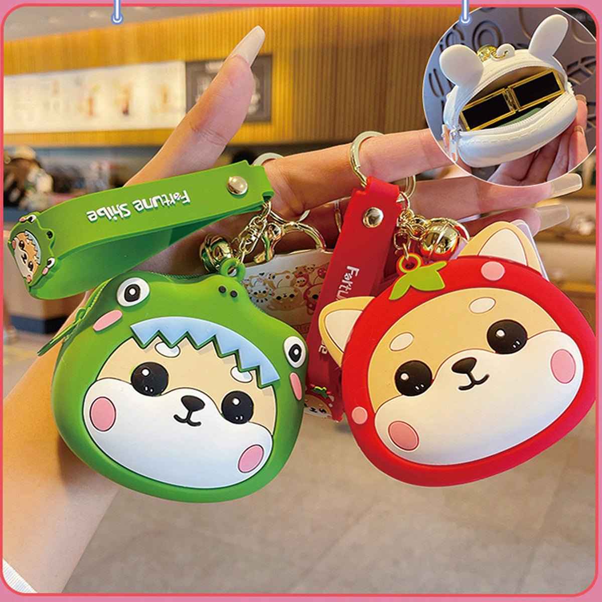 Two Shaketea Shiba Inu coin purses keychains in green dinosaur hood and red hood, zipper closures on Tampa Home & Garden Store