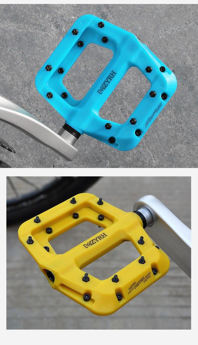 Flat platform bicycle pedals in blue and yellow with metal studs and rugged nylon body on Tampa Home & Garden Store