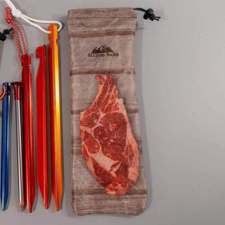 Ultralight tent stake bag with steak print on beige canvas by Hilltop Packs LLC; stakes on Tampa Home & Garden Store