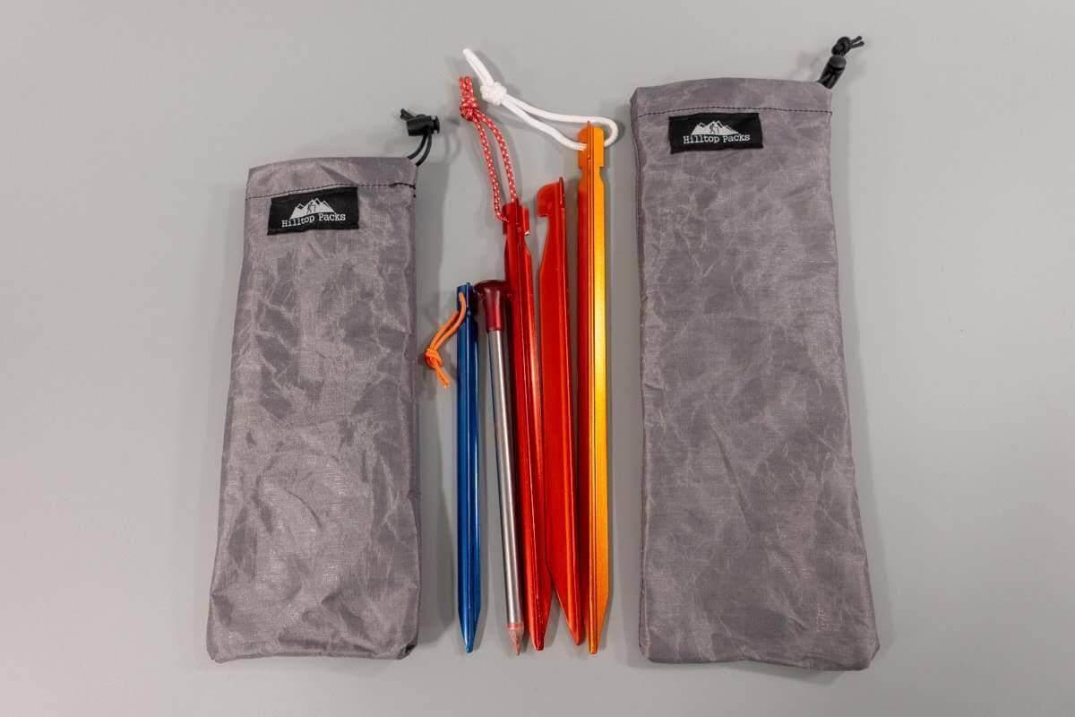 Ultralight tent stake stuff sack with colored stakes between two gray Hilltop Packs bags on Tampa Home & Garden Store