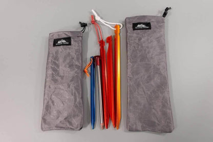 Ultralight tent stake stuff sack with colored stakes between two gray Hilltop Packs bags on Tampa Home & Garden Store