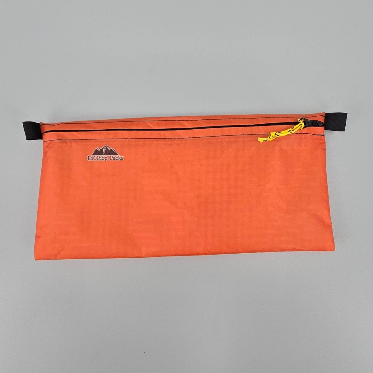 Ultralight zipper pouch organizer orange pouch with yellow cord pull Hilltop Packs LLC logo on Tampa Home & Garden Store