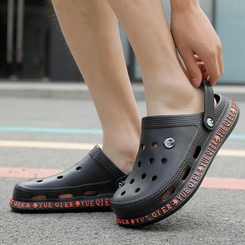 Stevvex unisex slip-on black sandals with perforated upper and orange branding on sole on Tampa Home & Garden Store