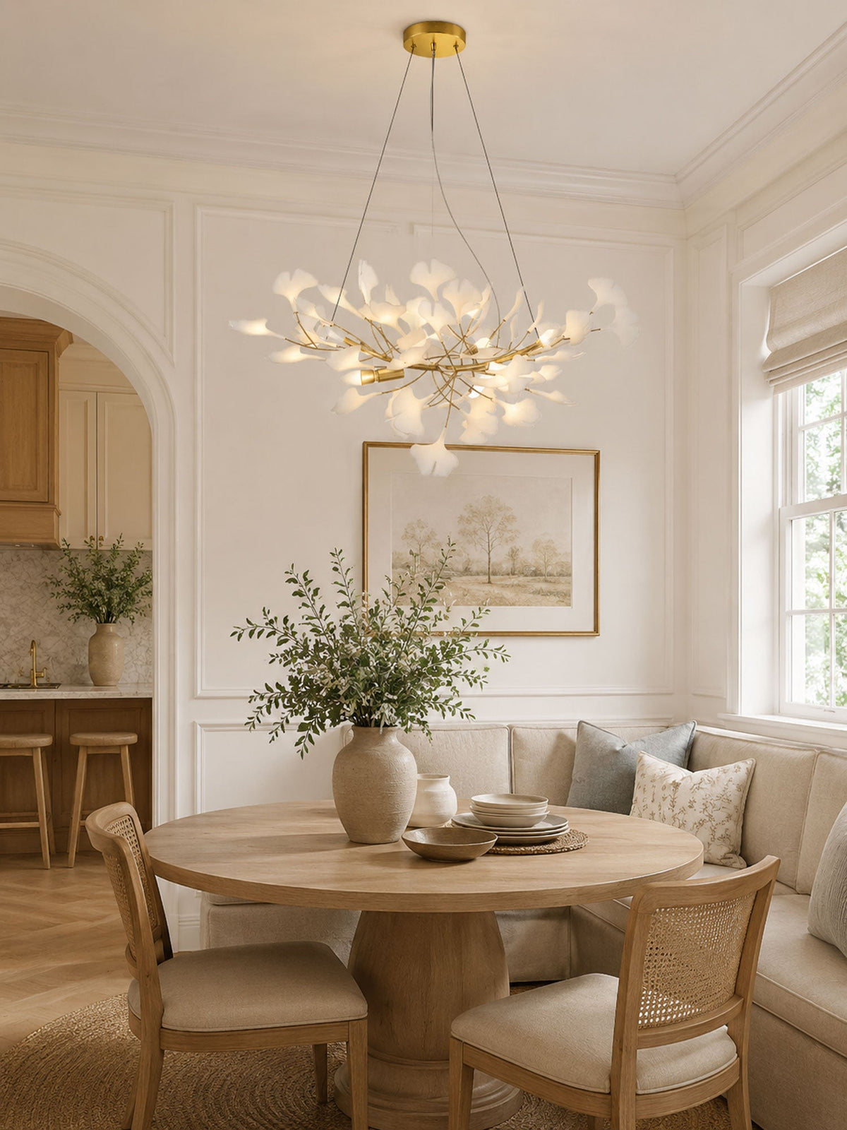 Porcelain ginkgo leaf linear chandelier with flexible gold branches over round dining table on Tampa Home & Garden Store