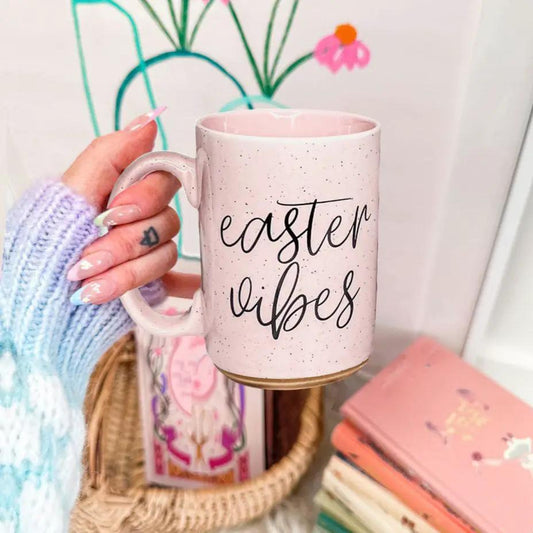 Gia Roma Easter Vibes 16.23oz pink speckled ceramic coffee mug with a gold base held by a pastel-nail hand on Tampa Home & Garden Store
