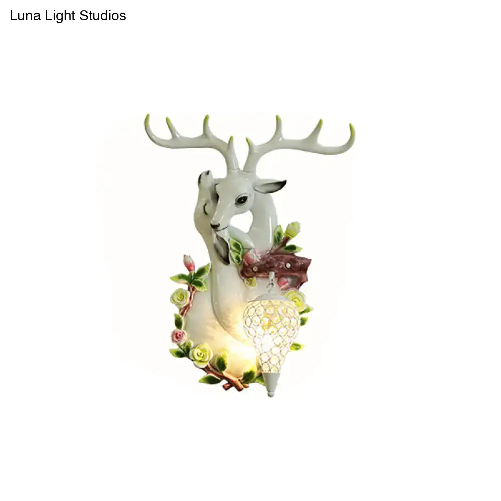 Gold deer crystal sconce with resin deer head, floral wreath, and lantern bulb by Decorbites on Tampa Home & Garden Store