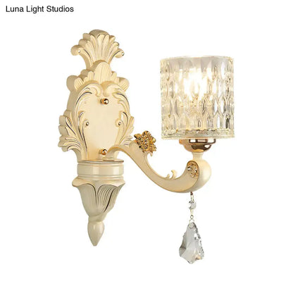 Gold crystal wall sconce with beige vintage finish, ornate backplate and hanging crystal drop on Tampa Home & Garden Store