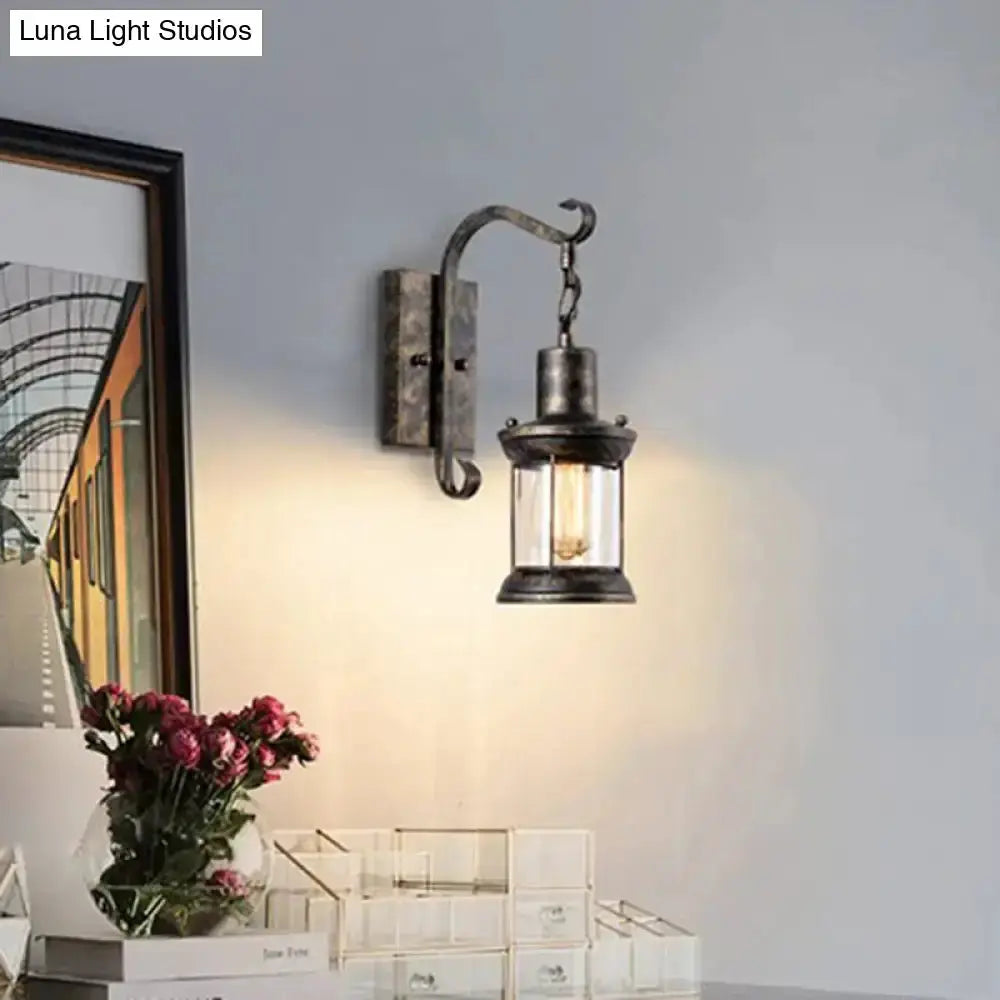 Vintage black lantern wall sconce with glass panels and curved mounting arm on Tampa Home & Garden Store