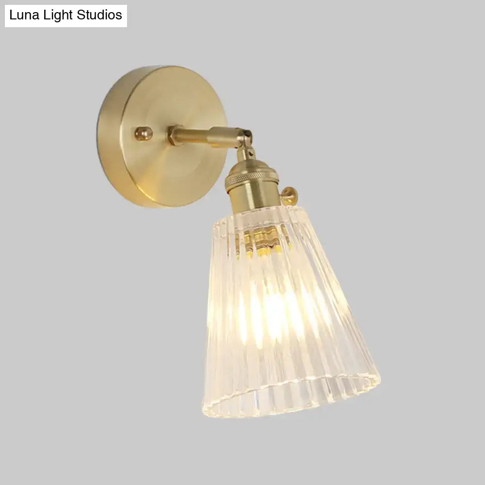 Vintage brass wall sconce with clear ribbed glass shade and LED bulb on Tampa Home & Garden Store