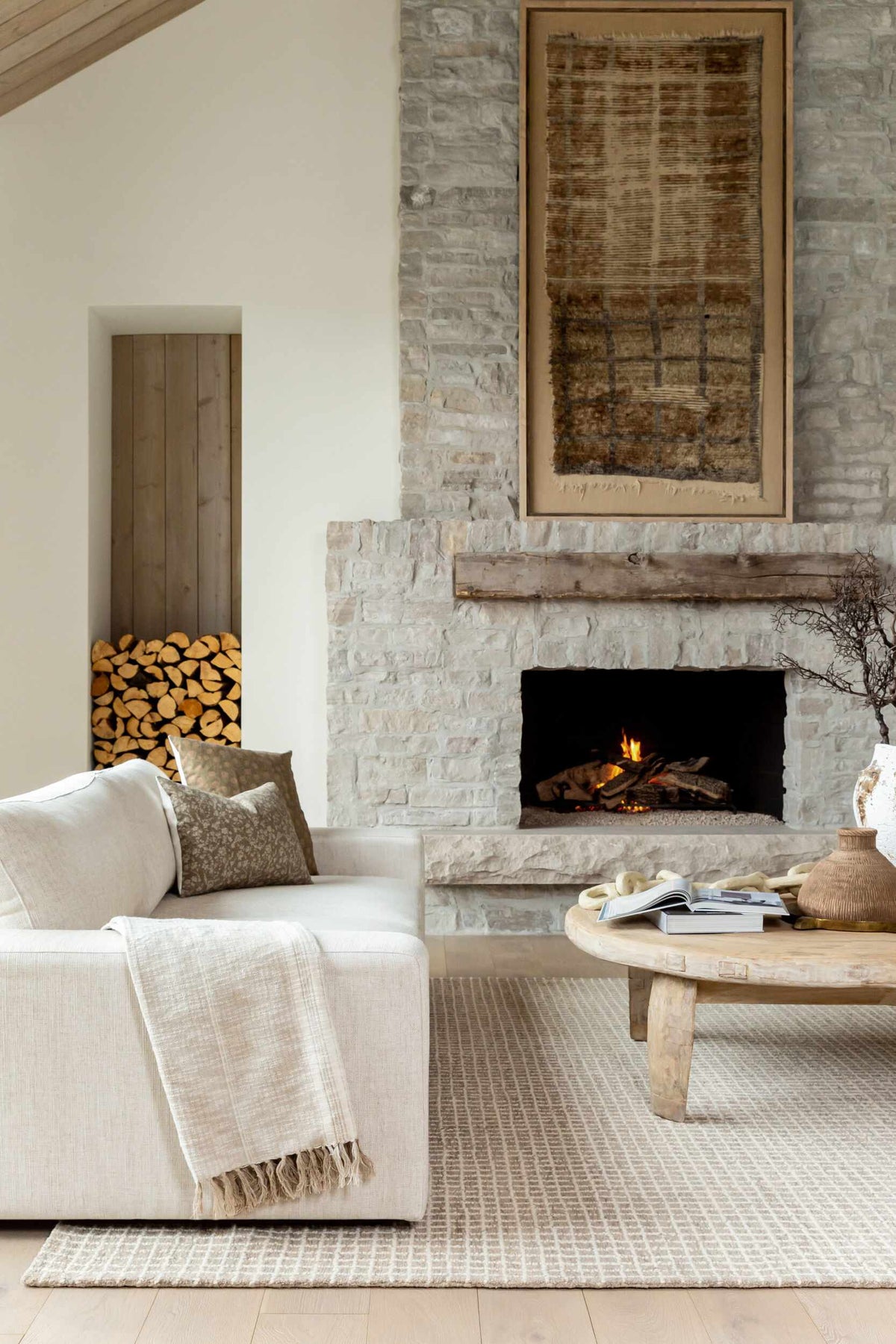 Anahid Bone Area Rug Boutique Rugs, beige textured rug in living room with stone fireplace on Tampa Home & Garden Store