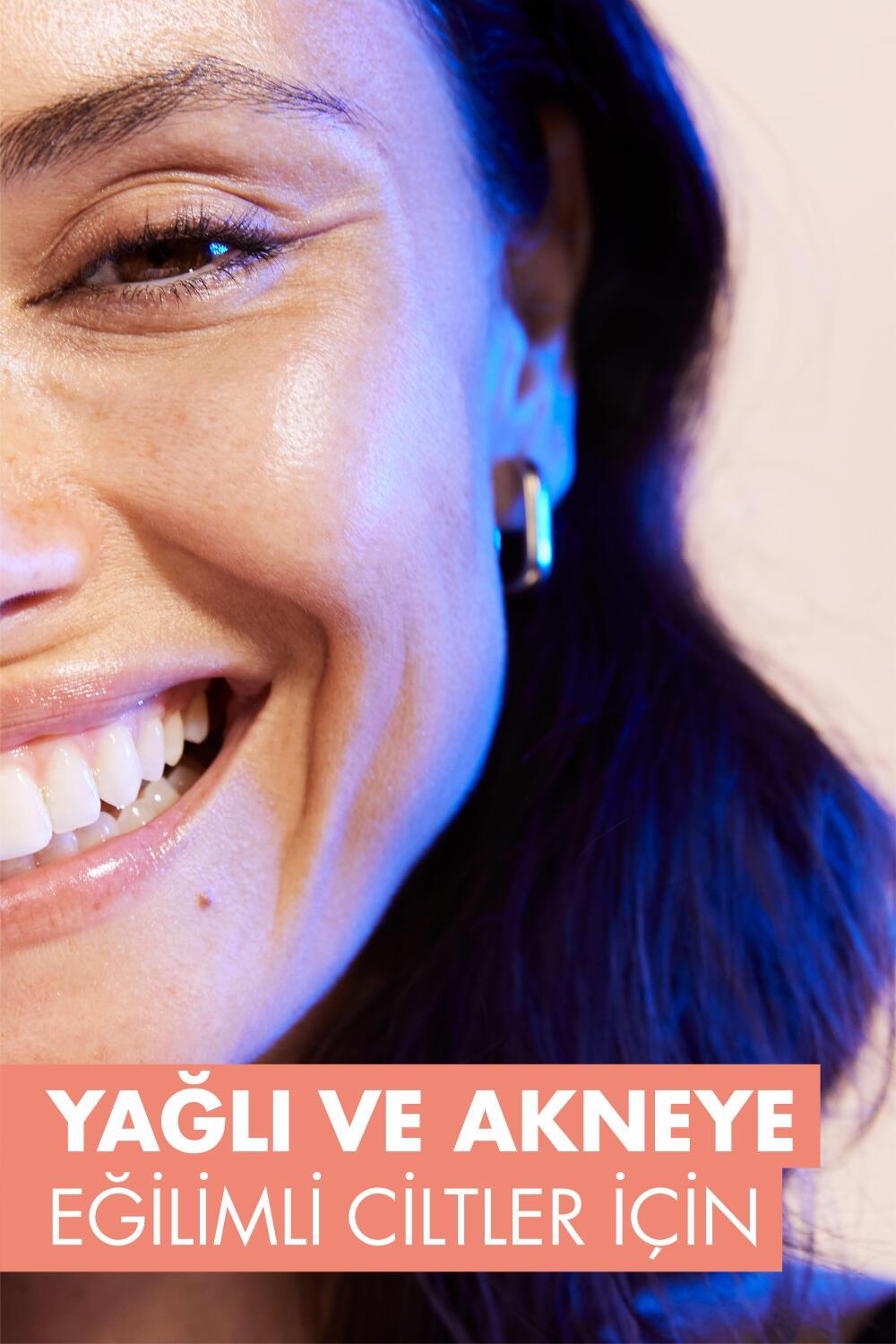 Sunscreen Avene Cleanance SPF 50+ tinted on a smiling woman under light with hoop earring on Tampa Home & Garden Store