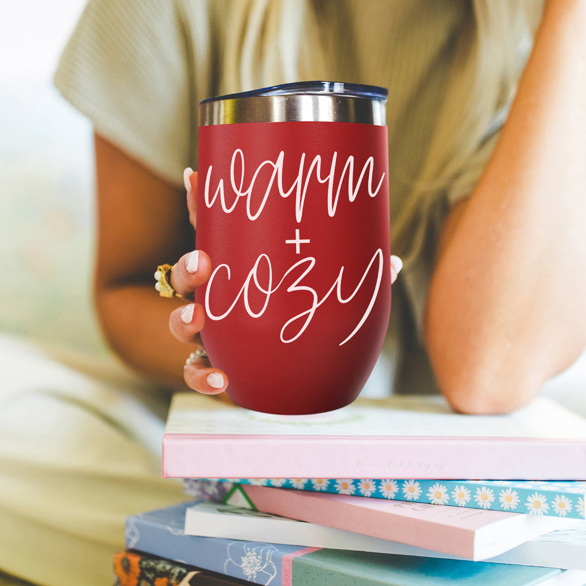 Warm + Cozy 17oz Gia Roma tumbler in red with white script, stainless steel lid, held in hand on Tampa Home & Garden Store