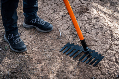 Weston rake by Backslope Tools, orange handle and black head on dirt on Tampa Home & Garden Store