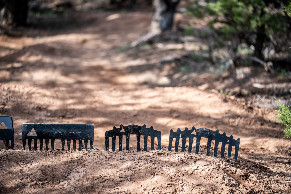 Weston rake heads by Backslope Tools, black metal tines lined up on dirt on Tampa Home & Garden Store