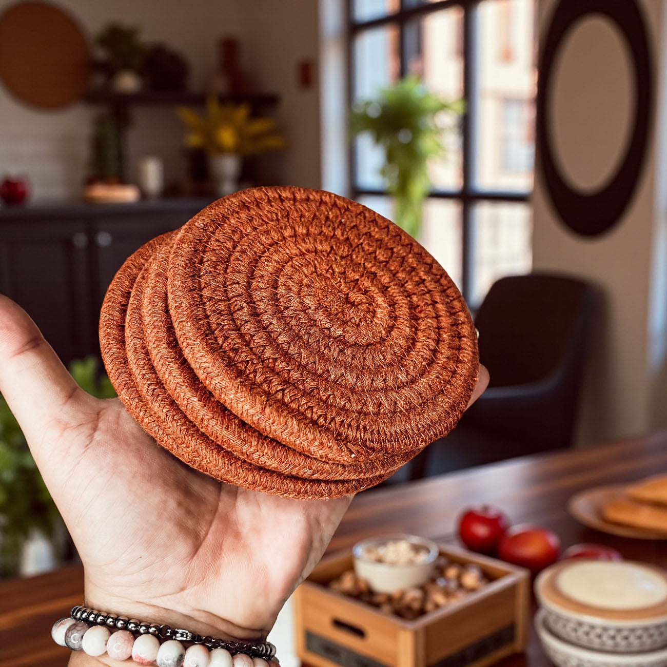 Fall Fabric Coasters Gia Roma, round rust-brown braided textile coasters stacked in hand on Tampa Home & Garden Store
