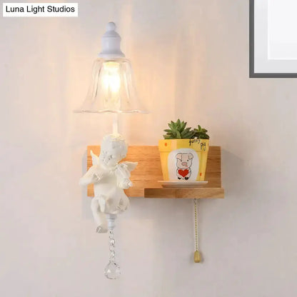 White angel ceramic wall sconce with crystal pendant and glass bell shade on a wood shelf on Tampa Home & Garden Store