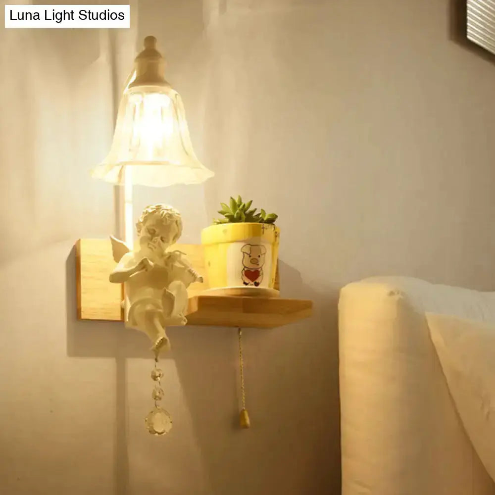 White angel ceramic bell shade wall sconce with crystal pendant on a shelf beside a plant on Tampa Home & Garden Store