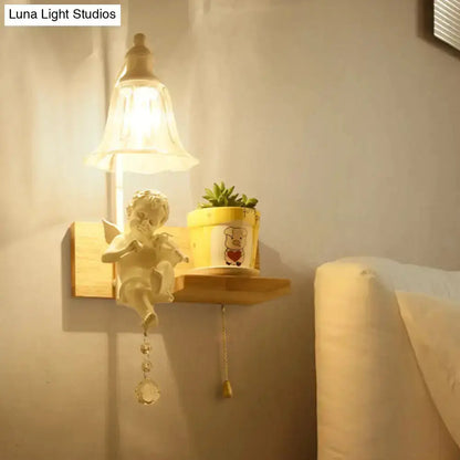 White angel ceramic bell shade wall sconce with crystal pendant on a shelf beside a plant on Tampa Home & Garden Store