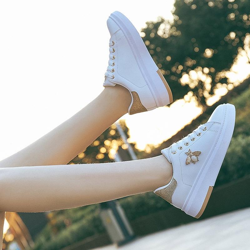 Pair of white Stevvex platform sneakers with rhinestone lace-up, glitter heel, bee emblem on Tampa Home & Garden Store