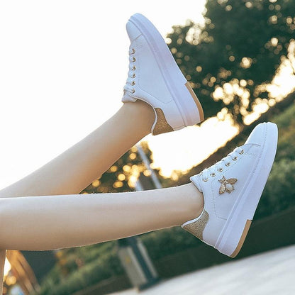 Pair of white Stevvex platform sneakers with rhinestone lace-up, glitter heel, bee emblem on Tampa Home & Garden Store