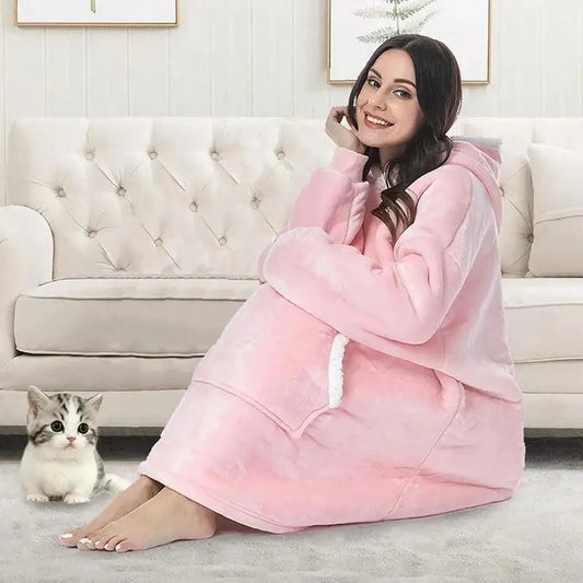 Oversized Wearable Blanket Hoodie pink plush fleece with hood and sleeves worn by woman on sofa on Tampa Home & Garden Store