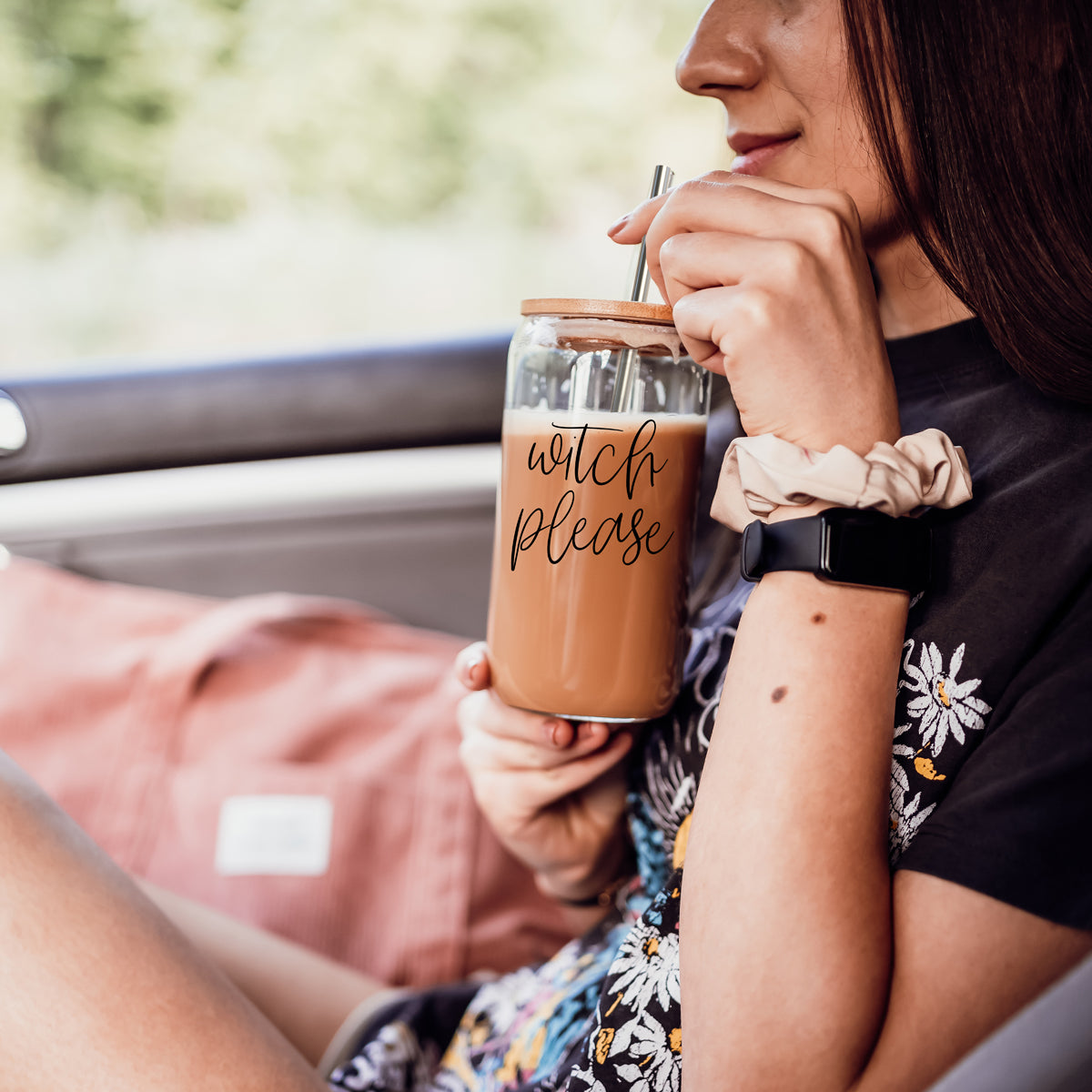 Witch Please 17oz travel mug with cork lid, tumbler, metal straw, held by woman in car on Tampa Home & Garden Store