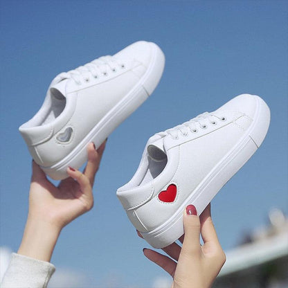 Pair of white PU leather women's sneakers with red heart side patch, breathable casual flats on Tampa Home & Garden Store