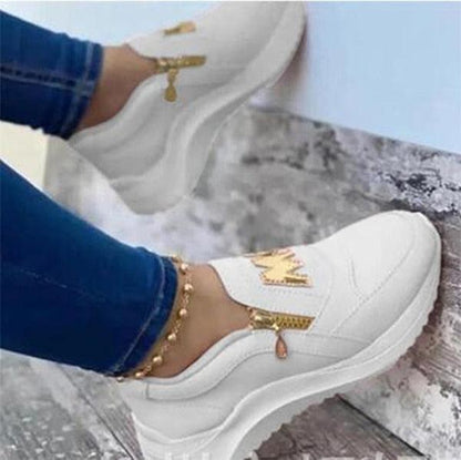 White women's slip-on sneakers with thick sole and gold zipper accents on Tampa Home & Garden Store