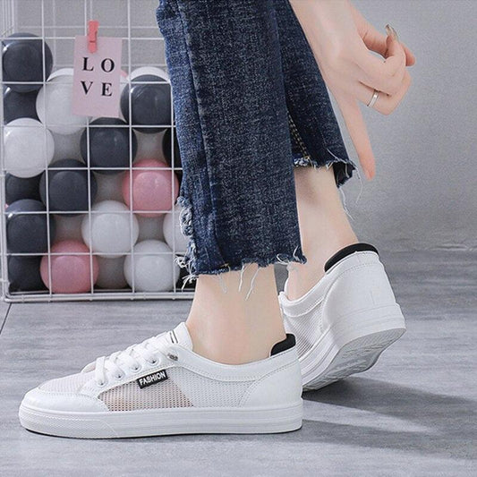 Women's white casual sneakers with mesh panels, lace-up front, black heel tab on Tampa Home & Garden Store