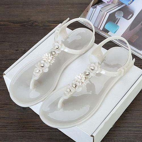 Women's jelly sandals with white floral embellishments, clear straps and T-strap design, pair on Tampa Home & Garden Store