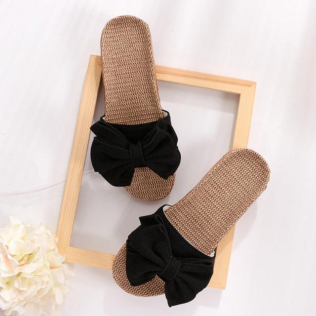 Women linen bow slide sandals pair with woven beige footbed and black bow strap on Tampa Home & Garden Store