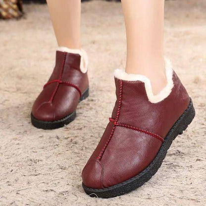 Pair of burgundy Stevvex leather winter boots with white plush fur lining and black sole on Tampa Home & Garden Store