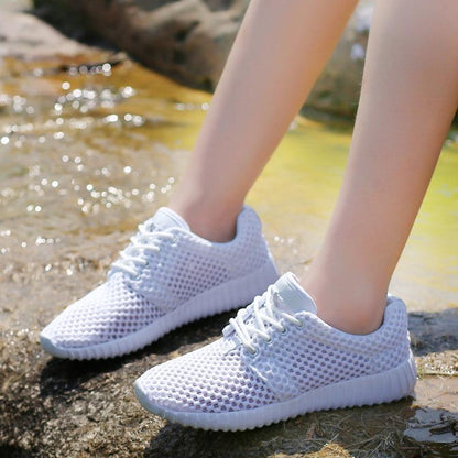 Stevvex women's lightweight breathable mesh lace-up sneakers white pair on rocky shore on Tampa Home & Garden Store