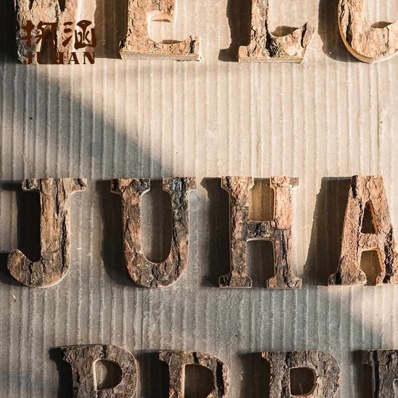 Wooden alphabet letters with rustic brown texture displayed on a corrugated surface on Tampa Home & Garden Store