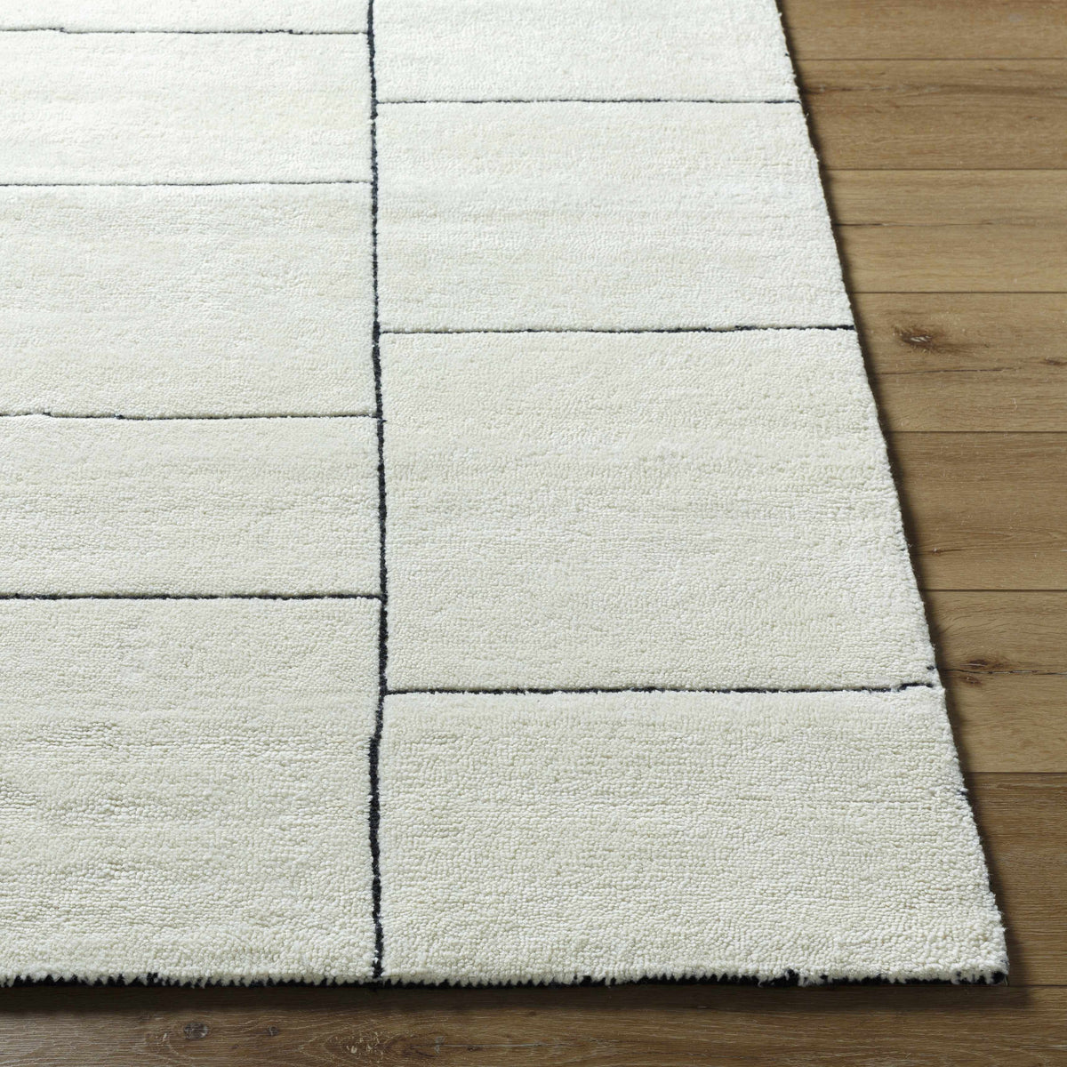 Xylia Ivory Area Rug by Boutique Rugs with ivory color and black grid pattern on wood floor on Tampa Home & Garden Store